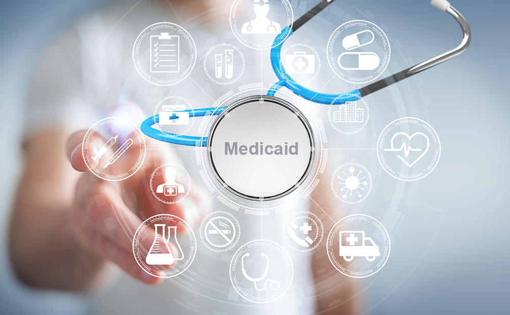 Digital image of doctor stethoscope with "Medicaid" in center and person pointing towards the camera.