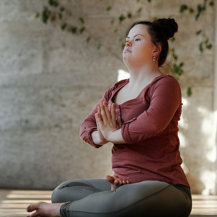 Young woman with down syndrome practicing yoga.